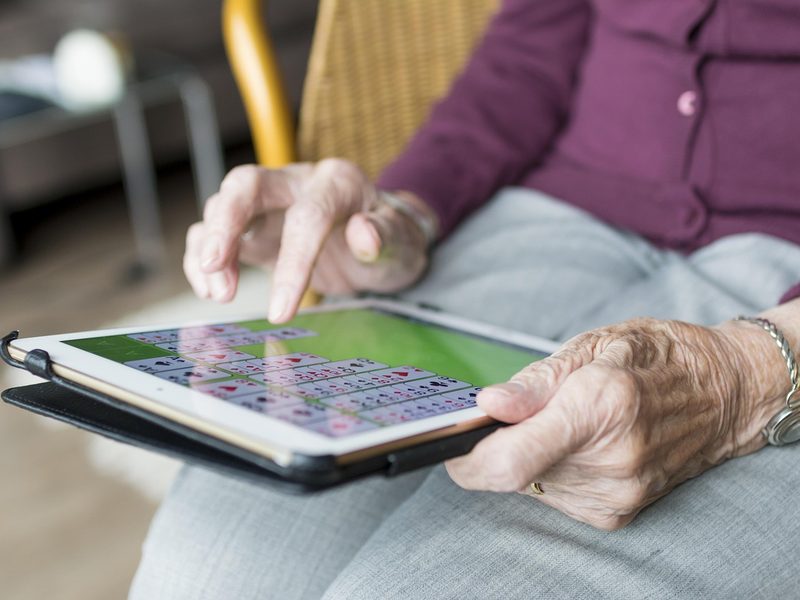 An older neighbor using a tablet at home